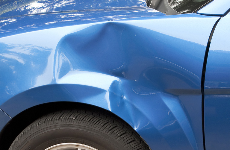 Auto accident leaving a huge dent in the left front quarter panel.
